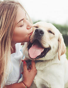 Beautiful woman kissing her dog